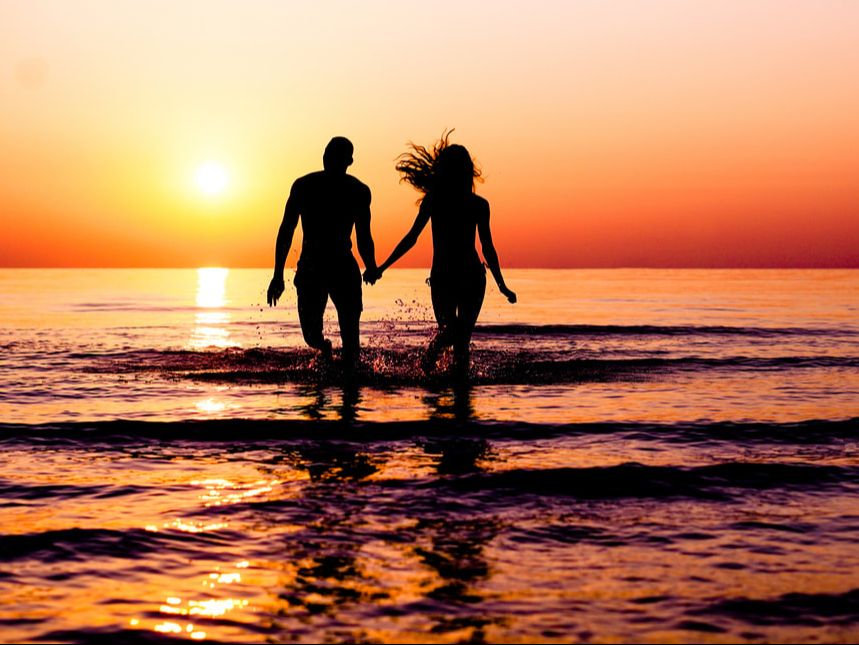 Couple in water at sunset